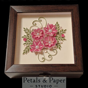 Handcrafted decorative box with a wooden frame, featuring a pink quilled floral design with pearl accents and green leaves, ideal for gifts or home decor.