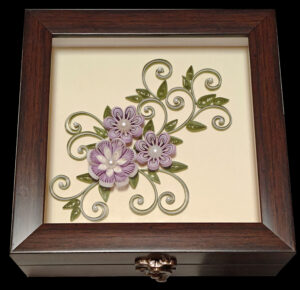 Handcrafted wooden decorative box featuring lavender and white quilled floral designs with green foliage and pearl embellishments, perfect for gifting or storing keepsakes.