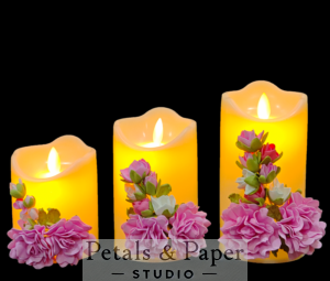 Set of three LED candles (4, 5, and 6 inches) decorated with pink and white foam flowers and green foliage, perfect for romantic settings, home décor, and Valentine's Day gifting.