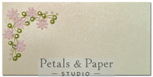 Handcrafted 7 x 3.5-inch pearl-finish envelope featuring pink quilled flowers, green vine accents, and pearl embellishments, perfect for weddings and special occasions.