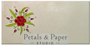 Handcrafted decorative envelope with quilled red roses, green leaves, pearl accents, and rhinestones on a shimmering ivory background, ideal for gifting on weddings, anniversaries, and festive occasions.