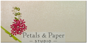 Handcrafted decorative envelope with pink quilled flowers, green leaves, pearl accents, and a ribbon bow on a shimmering ivory background, perfect for weddings, festivals, and gifting occasions.