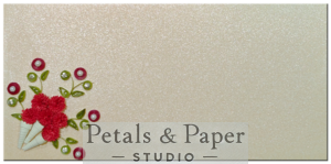 Handmade gift envelope with vibrant red quilled flowers in cone shapes, green leaves, rhinestone and pearl accents, on a shimmering textured background, perfect for gifting on special occasions.