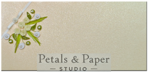 Handcrafted gift envelope with white quilled flowers, green leaves, pearls, rhinestones, and a white ribbon bow on a shimmering cream background, perfect for weddings and anniversaries.