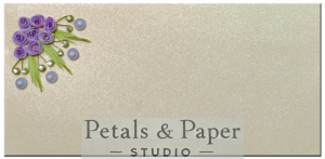 Handcrafted gift envelope with purple quilled roses, green leaves, pearl-like accents, and lavender circular quilling designs on a shimmering cream background, ideal for weddings and special occasions.