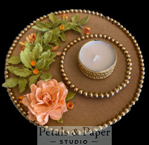 Handcrafted tea light holder plate with a peach rose, green leaves, orange accents, quilled designs, gold bead edging, and a gold tea light candle holder for festive décor.