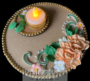 Handcrafted tea light holder plate with peach roses, white flowers, green quilled swirls, and gold bead edging, featuring an LED tea light candle for festive home décor.