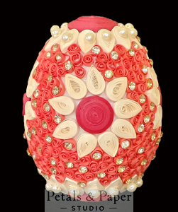 Handcrafted decorative egg featuring red and white quilled floral designs, accented with pearls and sparkling gems, perfect for weddings, festive décor, or gifting.