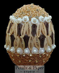 Brown and gold decorative egg featuring intricate quilling patterns, pearl embellishments, and rhinestones, ideal for elegant home decor or gifting.