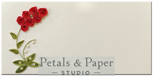 Handmade quilled envelope featuring red roses, green leaves, and pearl details, perfect for gifting on weddings, anniversaries, and celebrations.
