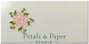 Handmade envelope with a star-shaped pink floral design, green quilled leaves, and pearl accents, ideal for weddings, festivals, and gifting.