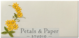Handmade envelope featuring yellow quilled flowers, green leaves, and pearl embellishments on a shimmering white background, ideal for gifting on special occasions like birthdays and weddings.