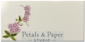 Handmade envelope adorned with pink quilled flowers, green leaves, and pearl accents on a shimmering white background, perfect for weddings, birthdays, and special occasions.