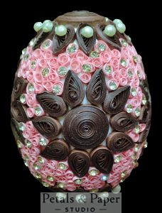 Handmade decorative egg with pink and brown quilling, pearl embellishments, and rhinestone accents, perfect for elegant home décor and gifting.