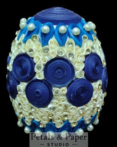 Handmade blue and cream decorative egg with intricate quilling, pearl embellishments, and rhinestone accents, perfect for home décor and gifting.