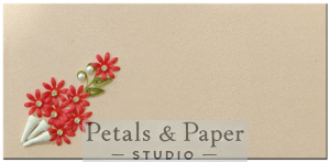 Handmade envelope with red quilled flowers in a white cone, green leaves, and pearl accents on a beige textured background, perfect for gifting on special occasions.