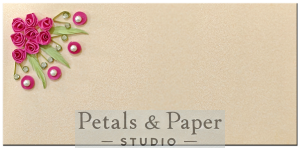 Handmade beige envelope with pink quilled roses, pearl embellishments, and green leaves, perfect for weddings and festive gifting.