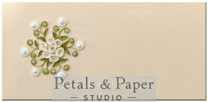 Handmade beige envelope with cream quilled roses, pearl embellishments, and green leaves, ideal for weddings and festive gifting.
