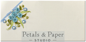 Handcrafted ivory gift envelope with blue quilled roses, green leaves, pearls, rhinestones, and a soft blue ribbon, perfect for weddings, birthdays, and festive gifting.