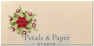 Handcrafted beige gift envelope with a central floral design featuring red quilled roses, green leaves, pearls, and rhinestones, perfect for weddings, anniversaries, and festive gifting.
