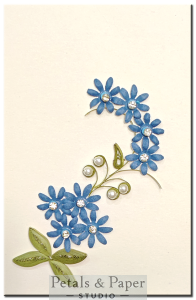 Handmade greeting card with cascading blue quilled flowers, rhinestones, and pearl decorations – perfect for birthdays, anniversaries, and special occasions.