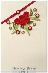 Handmade greeting card with red quilled carnation flowers, pearls, and ribbon on cream base – ideal for romantic or festive gifting.