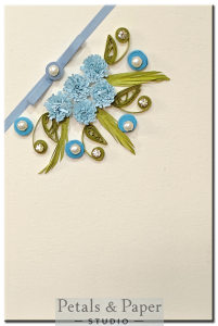 Handmade greeting card with blue quilled flowers, pearls, and ribbon on cream base – perfect for birthdays and baby shower gifting.