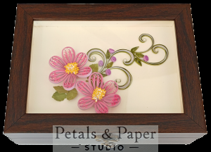Handcrafted wooden jewelry box with pink quilled paper flowers, yellow centers, and green vine design under glass cover