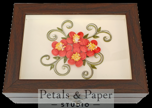 Handcrafted wooden jewelry box with red quilled paper flowers, yellow centers, and green vine design under glass cover