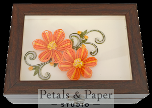 Handcrafted wooden jewelry box with two orange quilled paper flowers, yellow centers, green vines, and glass cover design