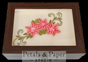 Handcrafted wooden jewelry box with three pink quilled star-shaped flowers, green leaves, swirling vines, and glass cover design