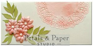 Handcrafted quilled envelope with blush pink paper flowers, green leaf accents, pearl embellishments and lace-inspired scalloped corner – luxury handmade gift envelope for weddings and special occasions