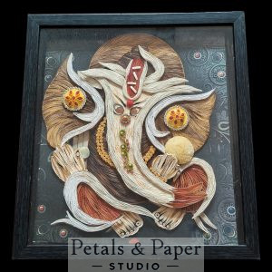 Handcrafted Lord Ganesha quilling art frame with intricate 3D paper craft design in earthy tones and black shadow box frame for spiritual home wall décor.
