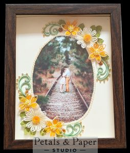 Handmade quilled floral photo frame with 5x7 inch photo area, orange and white flowers, green swirls and pearl border